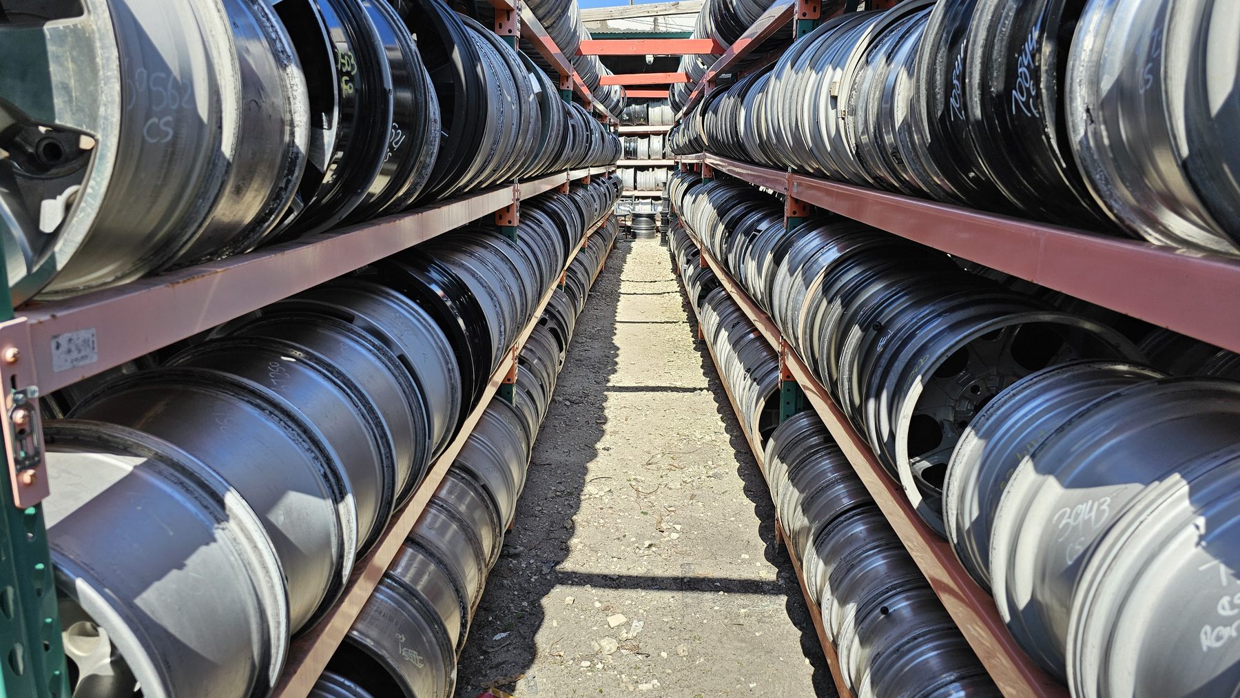 Rows of OEM wheels racked and sorted by interchange number in the AllOEMRims yard
